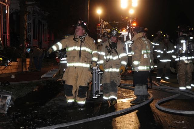 Firefighters Bill Goodley and Jay McKinney bringing an additional ladder to the scene.